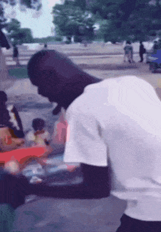 a man in a white shirt is standing on a sidewalk