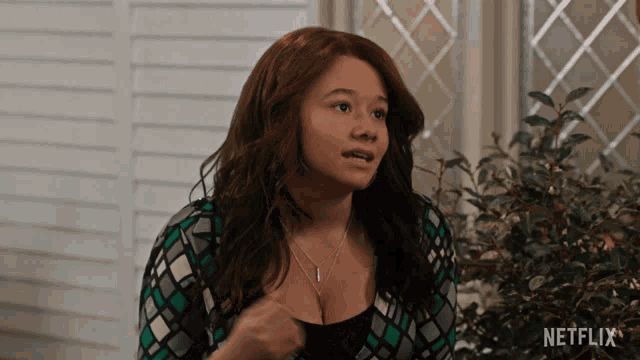 a woman in a green and black sweater with netflix written on the bottom