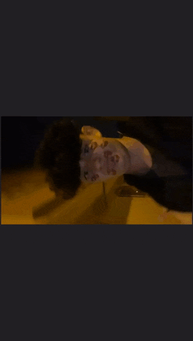 a person with kisses on their face is standing in the dark