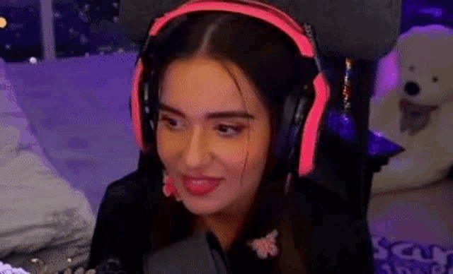 a woman wearing headphones and a microphone is sitting in a chair .