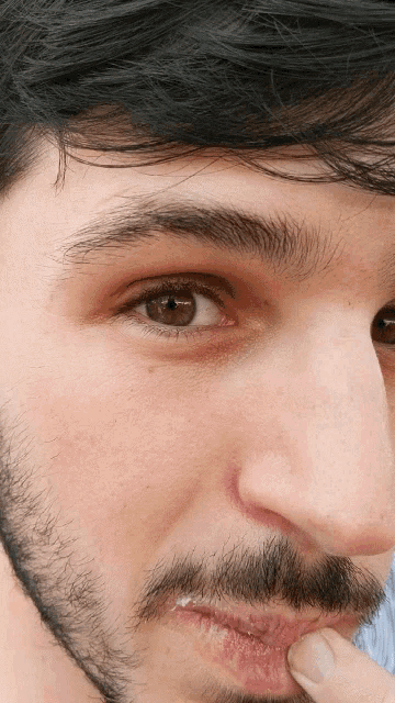 a close up of a man 's eye with a beard
