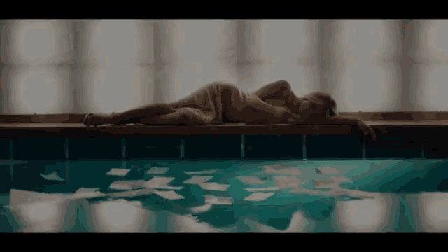 a woman laying on the edge of a pool