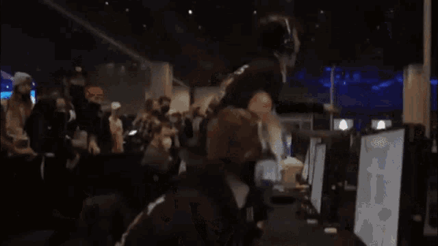 a crowd of people are gathered in a room with the words " & you suck " written on the screen