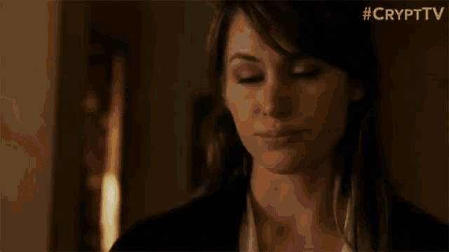 a close up of a woman 's face with her eyes closed in a dark room .
