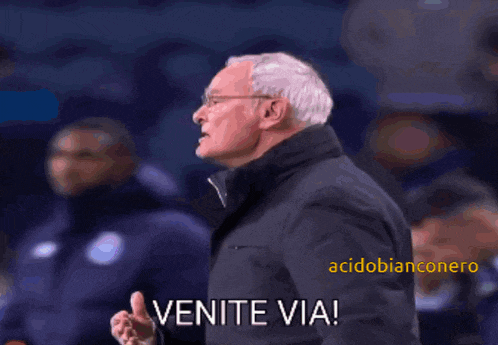 a man in a suit says venite via in a blurry photo