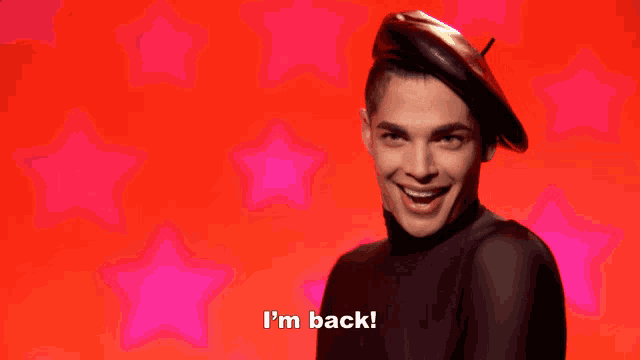 a man in a beret says i 'm back in front of a red background