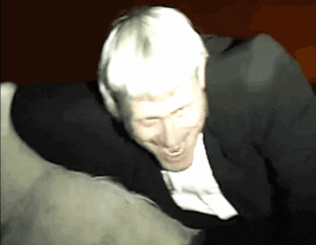 a man in a suit and tie is smiling and laughing