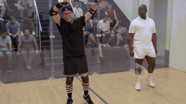 a man in a black shirt is holding a tennis racquet