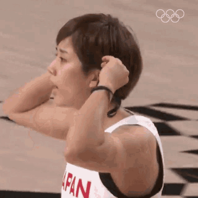 a woman in a japan jersey is tying her hair .
