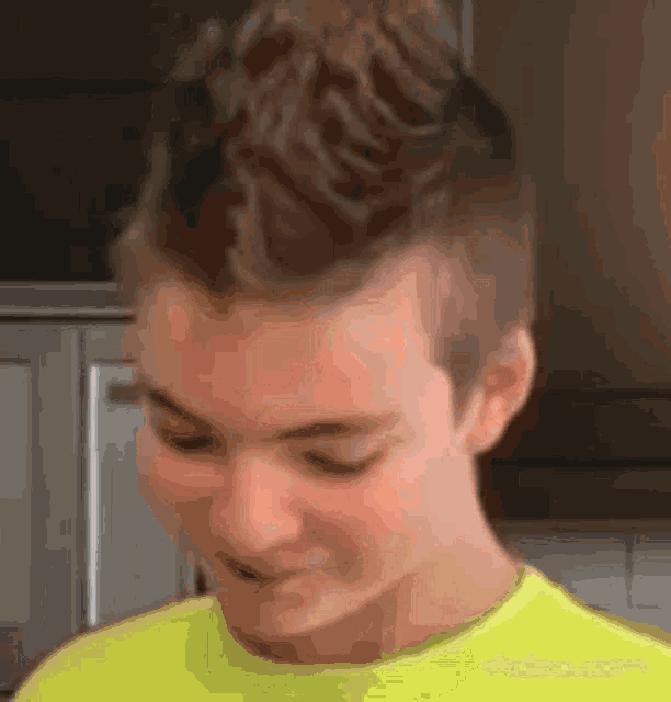 a close up of a person 's face in a yellow shirt