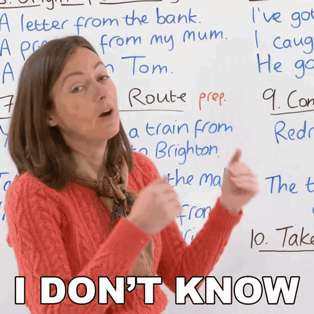 a woman giving a thumbs up in front of a whiteboard that says " i don 't know " on it