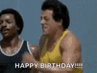 a man in a yellow tank top is standing next to another man and saying `` happy birthday '' .