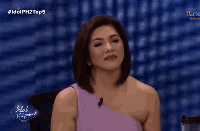 a woman sitting in front of a screen that says idol philippines on it