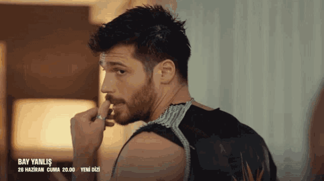 a man with a beard and a black tank top with the word bay yanlis on it