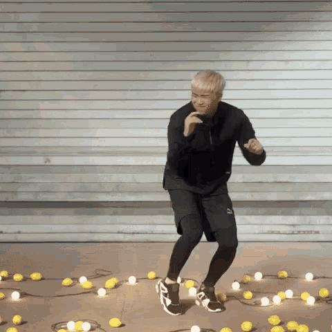 a man is dancing in front of a wall surrounded by lemons