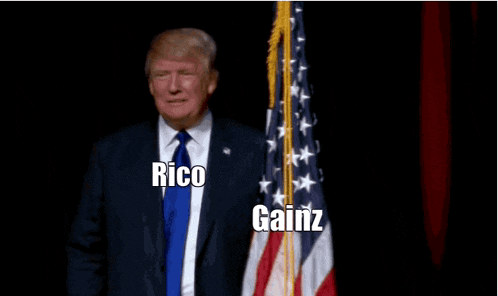 a man in a suit and tie is standing in front of an american flag with the words rico gainz above him