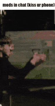 a gif of a man talking on a phone with the words mods in chat kiss ur phone