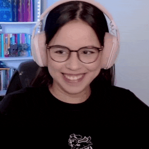 a woman wearing glasses and headphones is smiling in front of a bookshelf