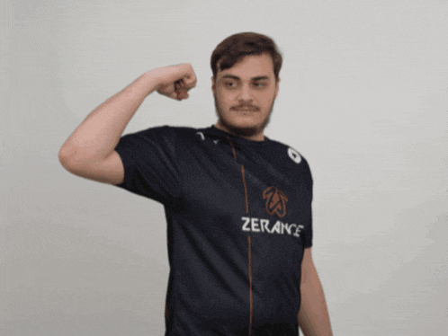 a man in a zerance shirt is flexing his muscles