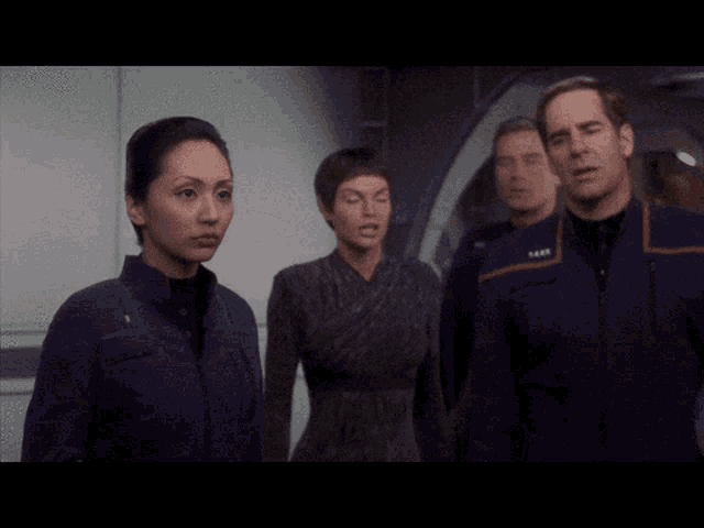 a group of people standing next to each other with one of them wearing a uniform that says ' crew ' on it