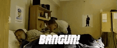two men laying on a bed in a room with the words bangun written in white letters