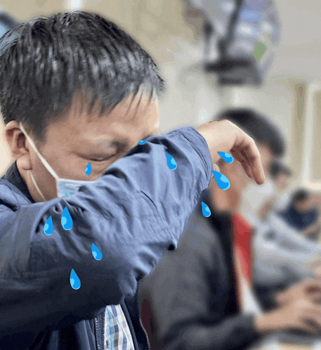 a man wearing a mask is crying with blue tears coming out of his eyes