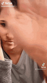 a woman is talking on a cell phone while looking at her face in a mirror .