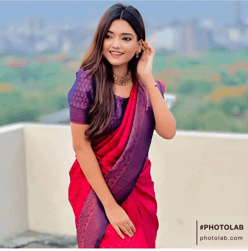 a woman wearing a pink and purple saree is standing on a rooftop