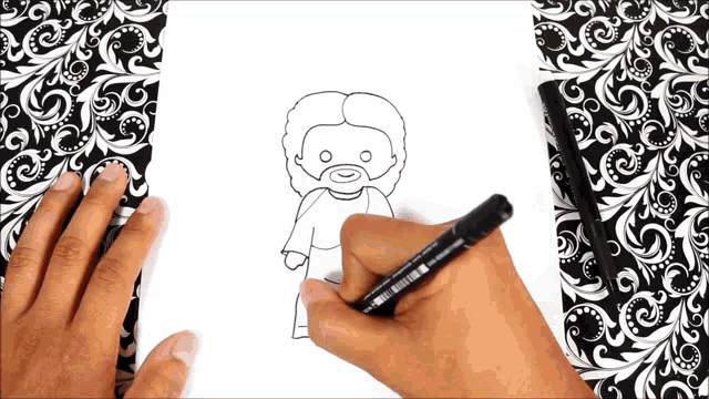 a person is drawing jesus on a piece of paper with a marker