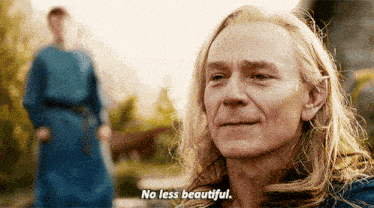 a man with long blonde hair has the words no less beautiful on his face