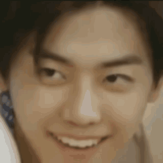 a close up of a man 's face with a smile on his face .