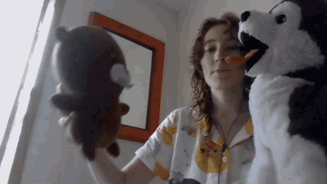 a woman is holding two stuffed animals in her hands