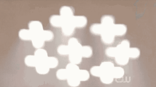 a blurred image of white crosses on a brown background with the cw logo in the corner