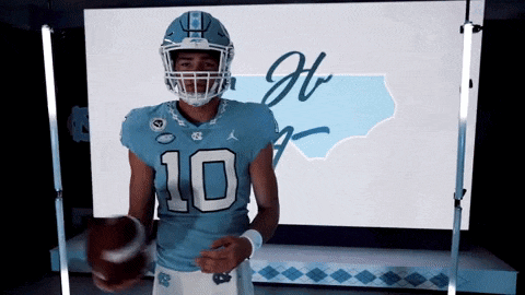 a football player wearing a number 10 jersey holds a football