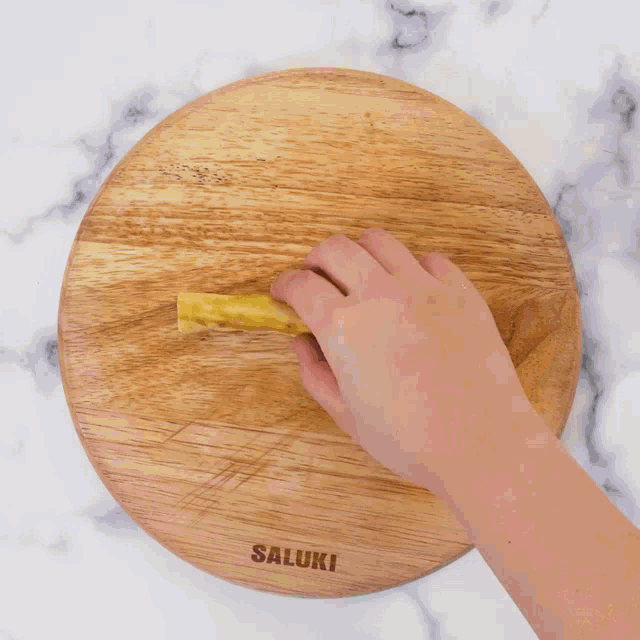 a person is spreading white frosting on a piece of bread