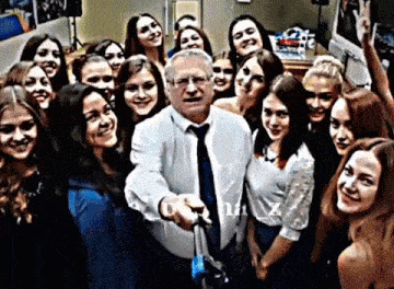 a group of women are posing for a photo with a man in a tie