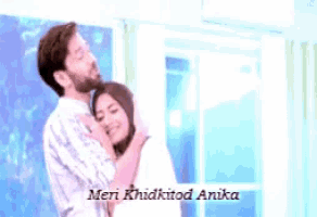 a man is touching a woman 's forehead with the words meri khidkitod anika written on the bottom