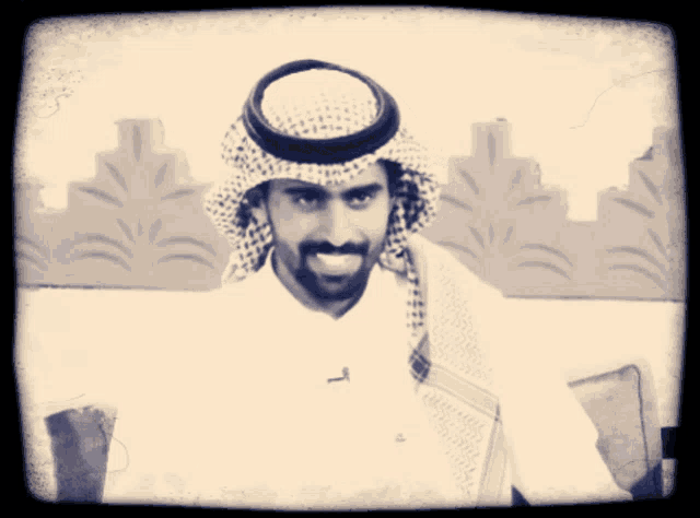 a man with a beard is wearing a white shirt and a scarf