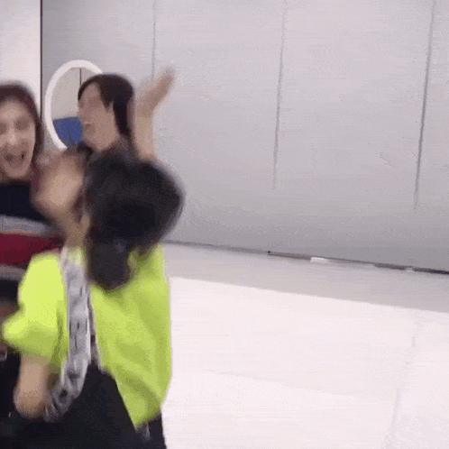 a group of people are standing next to each other and laughing in a room .