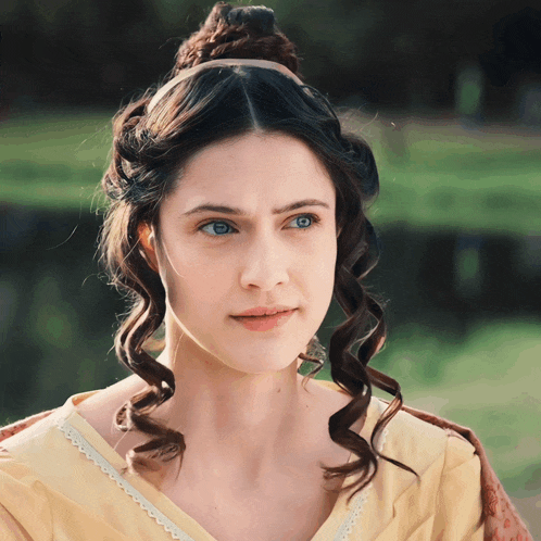 a woman in a yellow dress has a headband on her hair