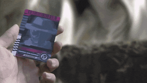 a person is holding a card that says kamen rider on it