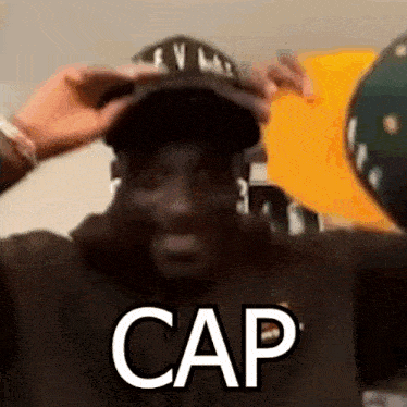 a man wearing a hat with the word cap on it is making a funny face .