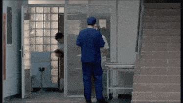 a man in a blue scrub top is talking to another man