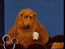 a group of stuffed animals are sitting in a theater with a disney logo
