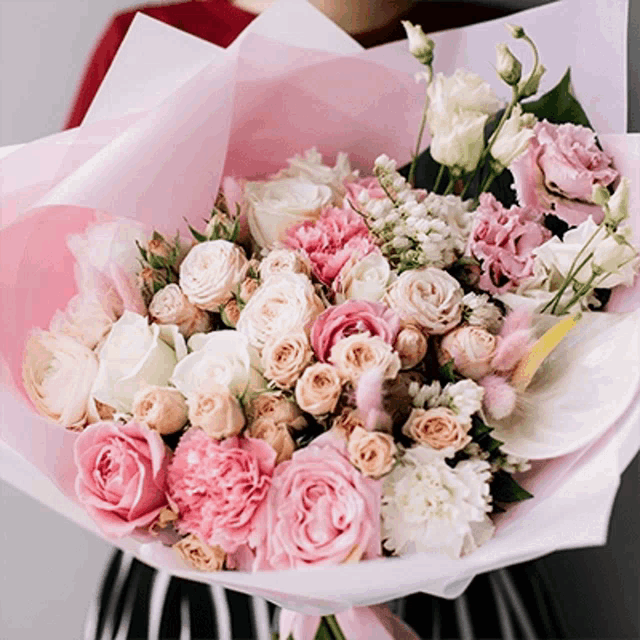 a woman holding a bouquet of pink and white flowers