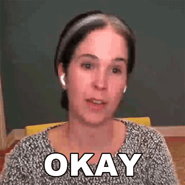a woman wearing a headband and ear buds says okay .