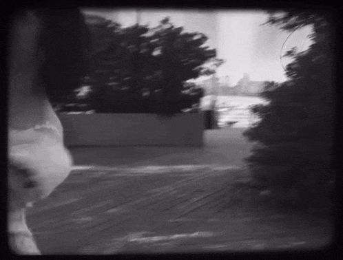 a black and white photo of a person walking down a path