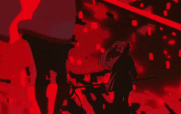 a man and a woman are standing next to each other in a dark room with red lights behind them .