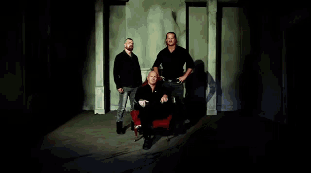 a group of men are posing for a picture in a dark room