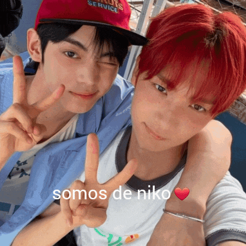 a man with red hair is giving a peace sign next to another man wearing a hat that says louis service